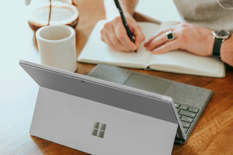 4-Ways-Small-Businesses-Can-Leverage-Microsoft-Copilot-for-SMBs-scaled.jpg a man sitting at a table writing on a notebook