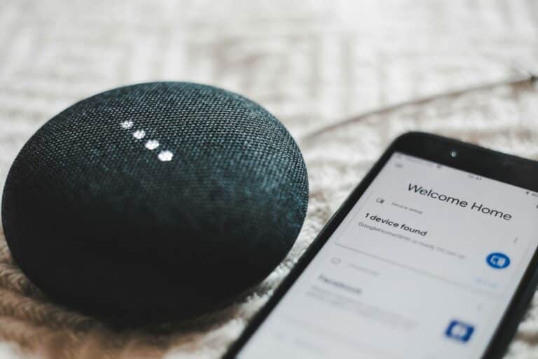 Smart-Tips-for-Building-a-Smart-Home-on-a-Budget-scaled.jpg turned-on charcoal Google Home Mini and smartphone
