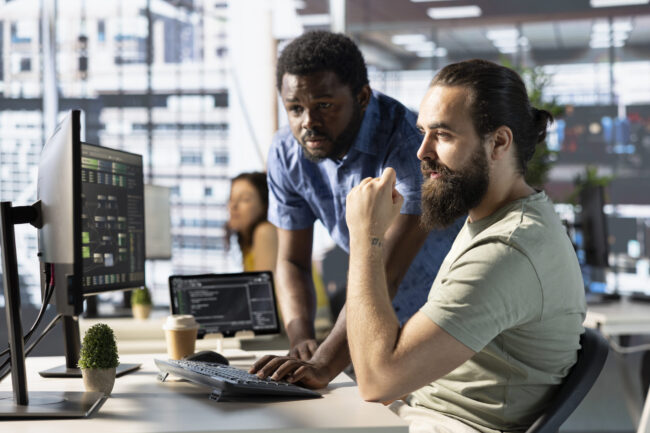 Programmer and colleague in office, training machine learning algorithms