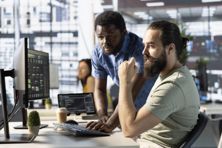 Programmer and colleague in office, training machine learning algorithms